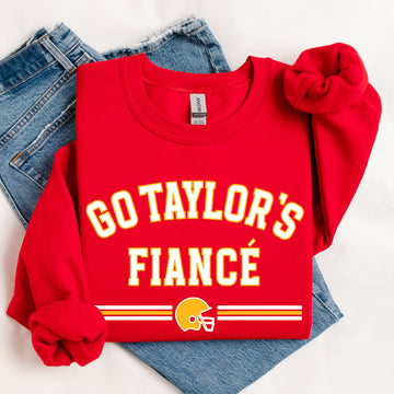 Red sweatshirt with 'GO TAYLOR'S FIANCÙ' text and football helmet graphic on a white background.
